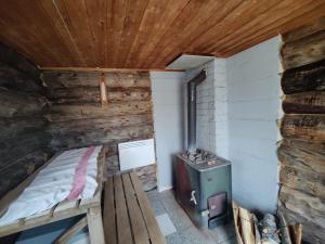 a small room with a bed and a stove at Villa Lavijoki in Karesuvanto