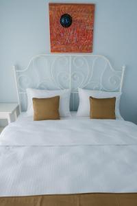 a white bed with a blue headboard and two pillows at Gadura Kır Evleri Urla in Urla