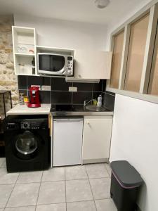 a small kitchen with a microwave and a sink at Vaste Appartement Rénové - Centre Ville in Bourg-en-Bresse