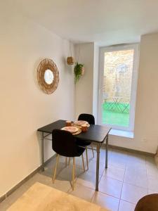 una sala da pranzo con tavolo, sedie e finestra di Vaste Appartement Rénové - Centre Ville a Bourg-en-Bresse