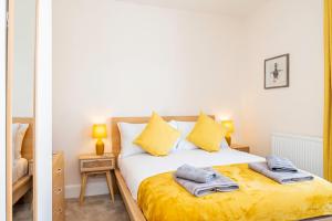 a bedroom with a bed with yellow sheets and yellow pillows at Modern Home Near South Parade Pier in Portsmouth
