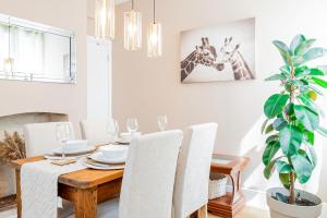 a dining room with a table and a giraffe picture on the wall at Modern Home Near South Parade Pier in Portsmouth