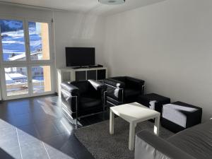 sala de estar con 2 sillas y TV en Casa a Suglegl en Savognin