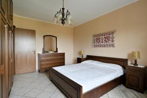 une chambre avec un lit, une commode et un miroir dans l'établissement La Collina degli Ulivi, à Bari Sardo