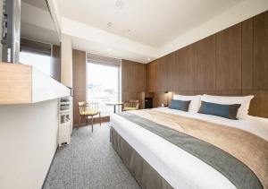 una habitación de hotel con una cama grande y una mesa en Tokyu Stay Sapporo en Sapporo