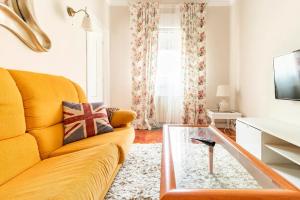 - un salon avec un canapé jaune et une table basse dans l'établissement Apartamento Centro de Santander, à Santander