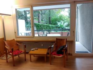 ビッソーネにあるLago di Lugano a Bissoneの椅子2脚とテーブル1台と窓のある部屋