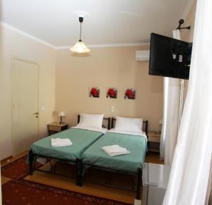 a bedroom with a bed and a flat screen tv at Lefcothea Guest Rooms in Lákka