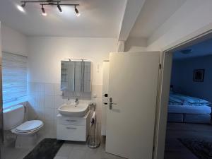 a bathroom with a sink and a toilet and a bed at Höpers Wohnpark in Wolthausen