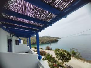 a blue pergola with a view of the water at Marisini Sea View in Batsi