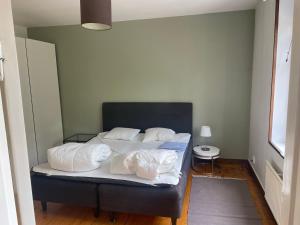 1 dormitorio con 1 cama con sábanas y almohadas blancas en Apartment Garbo, en Estocolmo
