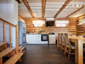Il comprend une cuisine avec des appareils blancs et un plafond en bois. dans l'établissement Jõemaja, à Oiu