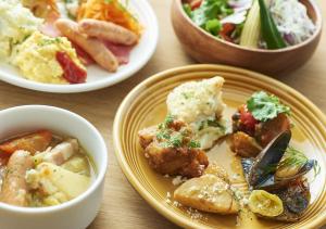 une table avec des assiettes et des bols de nourriture dans l'établissement Tokyu Stay Sapporo, à Sapporo