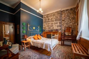 1 dormitorio con cama y pared de piedra en Poet's Cottage Stanley, en Stanley