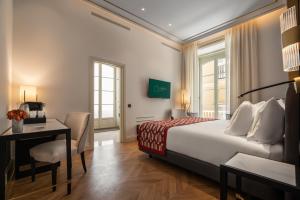 a hotel room with a bed and a desk and a bed and a room at Áurea Casa Palacio Sagasta by Eurostars Hotel Company in Cádiz