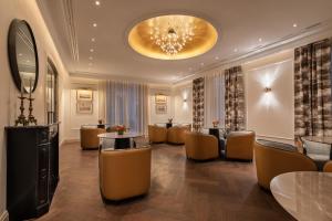 a hotel lobby with chairs and tables and a chandelier at Áurea Casa Palacio Sagasta by Eurostars Hotel Company in Cádiz