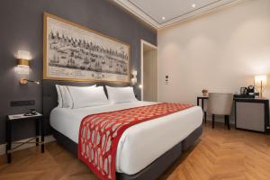a hotel room with a large bed and a table at Áurea Casa Palacio Sagasta by Eurostars Hotel Company in Cádiz