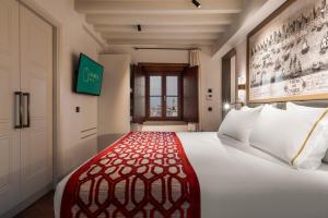a bedroom with a bed with a red and white bedspread at Áurea Casa Palacio Sagasta by Eurostars Hotel Company in Cádiz