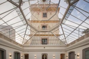 a glass ceiling in a room with a building at Áurea Casa Palacio Sagasta by Eurostars Hotel Company in Cádiz
