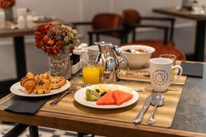 a breakfast table with two plates of food and drinks at Áurea Casa Palacio Sagasta by Eurostars Hotel Company in Cádiz