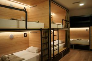 a room with three bunk beds and a mirror at Hostel Stadion - Zadar in Zadar
