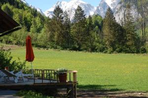 eine Terrasse mit einem Sonnenschirm, einem Tisch und einem Stuhl in der Unterkunft Haus Bergblick in Hinterstoder