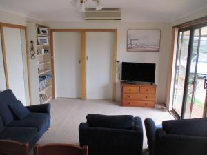 a living room with a tv on a wooden dresser at Shack 93 - James Well in Perara