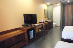 ein Hotelzimmer mit einem TV und einem Schreibtisch mit einem Bett in der Unterkunft Avatar Railay in Railay Beach