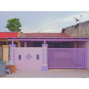 a pink house with a purple fence in front of it at Gooday homestay in Skudai