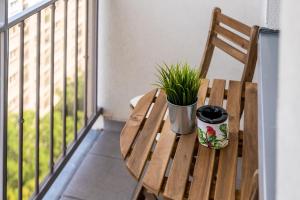 a wooden bench with a potted plant on a balcony at Kairos Apartments - Spodek - 100 m od Spodka in Katowice