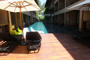 a pool with chairs and an umbrella next to a building at Avatar Railay in Railay Beach