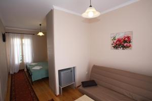 a living room with a couch and a television at Lefcothea Guest Rooms in Lákka