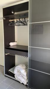 a walk in closet with black shelves and white towels at Maison Flore Arena, Gendarmerie, Rocade in Bouliac
