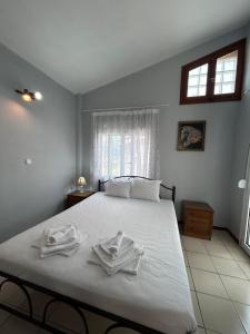 una camera da letto con un grande letto bianco con asciugamani di Maria's maisonette Nea Iraklitsa a Iraklitsa