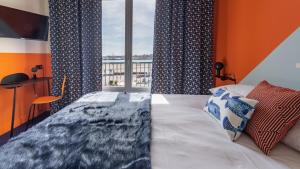 - une chambre avec un lit et une grande fenêtre dans l'établissement Seakub hotel, à Royan