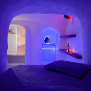 Dormitorio púrpura con cama y ventana en Abyssanto Suites and Spa, en Imerovigli