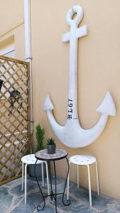 a anchor on the side of a wall with a table and chairs at ZOIS APARTMENT in Artemida