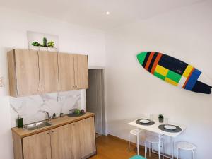 a kitchen with a sink and a surfboard on the wall at ZOIS APARTMENT in Artemida