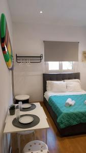 Un dormitorio con una cama y una mesa con platos. en ZOIS APARTMENT, en Artemida