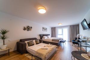 a living room with a couch and a bed at Hotel Fuchs & Hase SELF CHECK IN in Rosegg