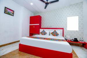 FabHotel Golden Temple Paradise في أمريتسار: غرفة نوم بسرير احمر و اللوح الأمامي احمر
