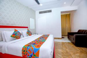 a bedroom with a large bed and a couch at FabHotel Golden Temple Paradise in Amritsar