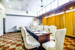 a dining room with a long table and white chairs at FabHotel Golden Temple Paradise - 50 meters from Golden Temple in Amritsar