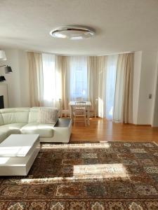 Una sala de estar con un sofá blanco y una mesa. en Blackforest FeWo, en Freudenstadt