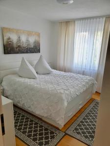Un dormitorio con una cama con sábanas blancas y una ventana. en Blackforest FeWo, en Freudenstadt 7 fotos más