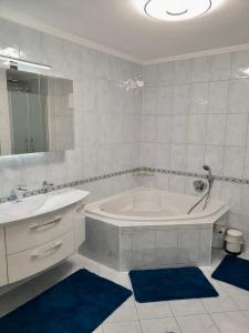 a white bathroom with a tub and a sink at Blackforest FeWo in Freudenstadt +7 photos