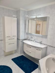 Baño blanco con lavabo y espejo en Blackforest FeWo, en Freudenstadt