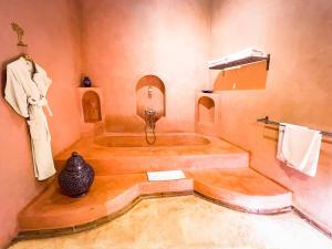 a bathroom with a tub with a vase on the wall at Riad Selouane in Marrakesh