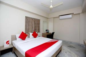 a bedroom with a large white bed with red pillows at Collection O Tulsi Palace in Nager Bazaar