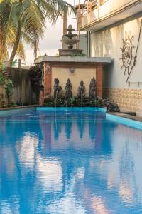 a large blue swimming pool with a fountain at Townhouse, Pool & Kitchen, Ubud, Cucus Mondok in Ubud